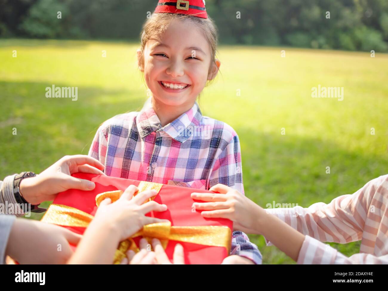 Felice bambina nel cappello rosso di Santa e tenendo Natale presenta Foto Stock