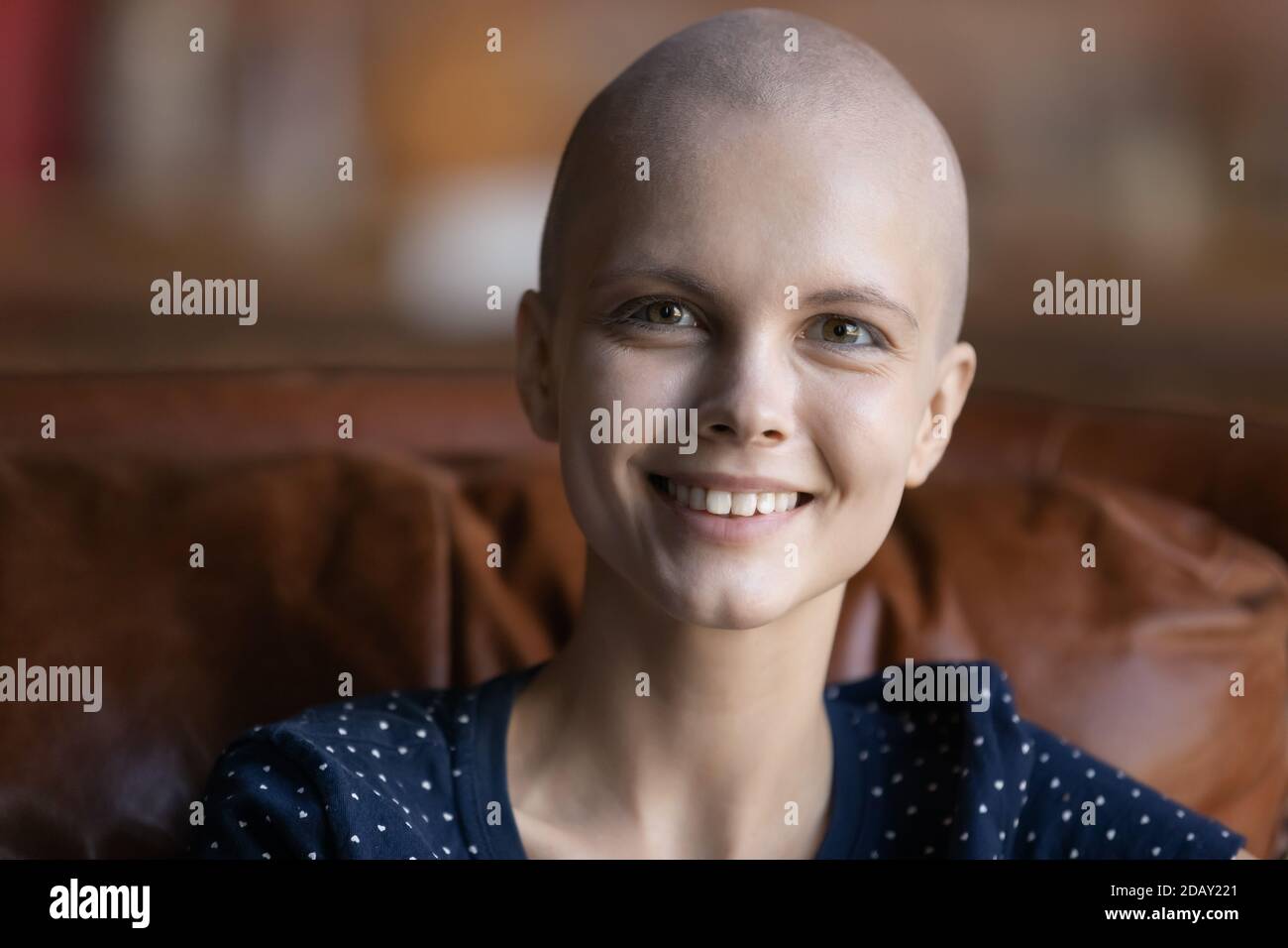 Paziente oncologico donna ottimista seduto sul divano guardando la telecamera Foto Stock