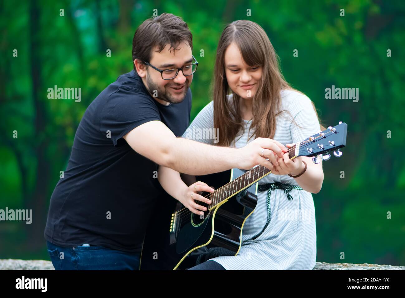 Fratello insegnava a suonare la chitarra in natura Foto Stock