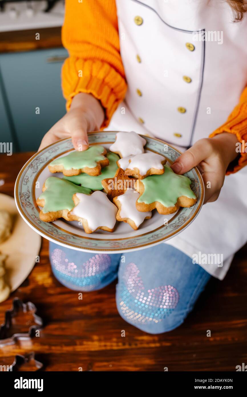 La ragazza ha cucinato i biscotti per celebrare il Natale in cucina a casa. Buon Natale e Felice Anno Nuovo. Cucina e concetto di vacanza Foto Stock