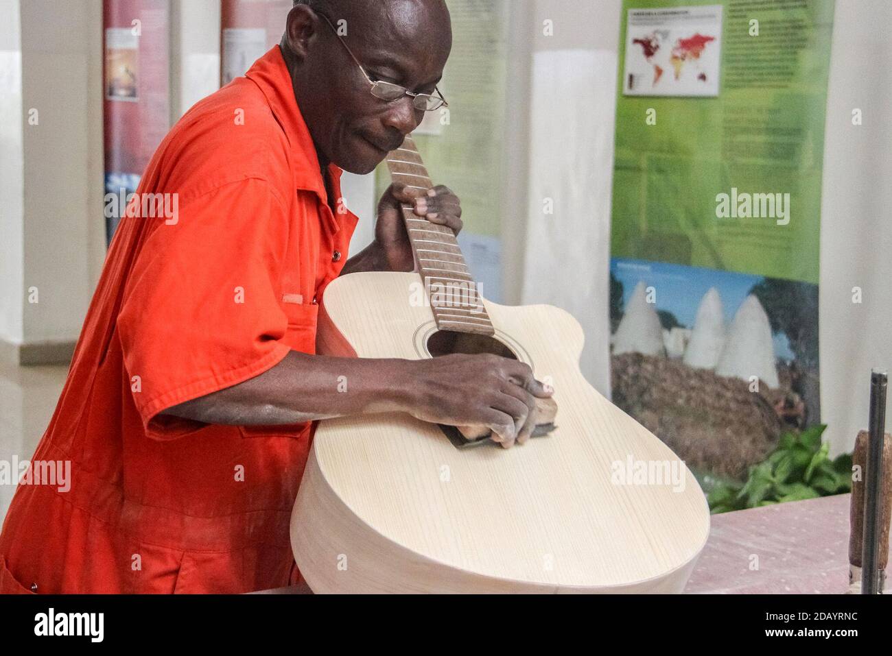 Un uomo sabbia una chitarra che sta facendo a Bukavu, la capitale della provincia del Kivu del Sud nella Repubblica Democratica del Congo. Foto Stock