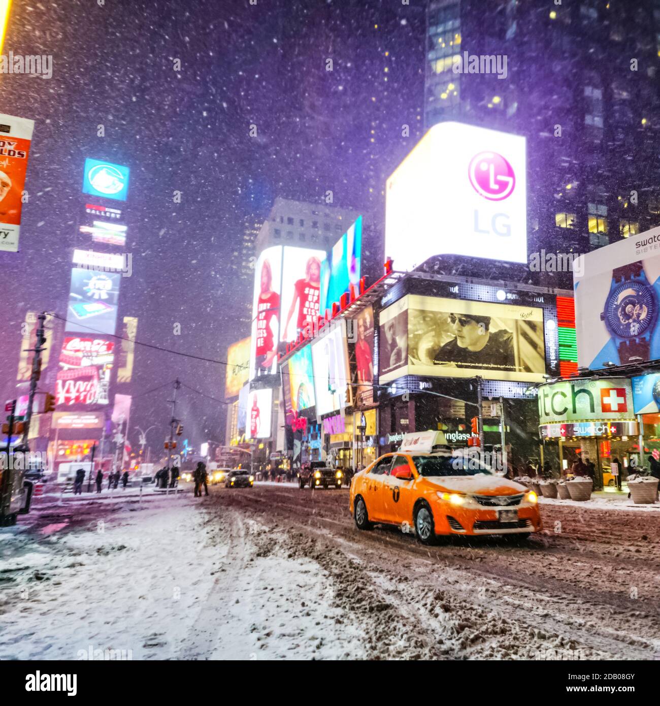 Times Square in inverno, tempesta di neve frizzante con gente che si trova in viaggio e auto e taxi sulle strade di New York. Foto Stock