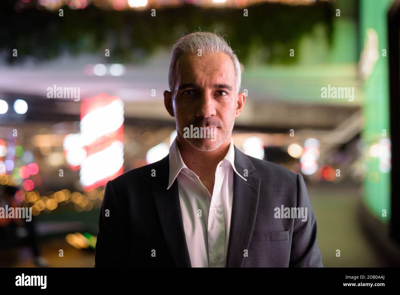 Ritratto di bell'uomo d'affari che indossa il vestito in città di notte Foto Stock