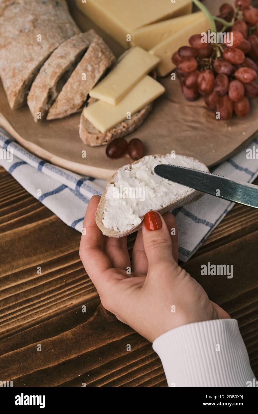 Primo piano foto di pane di Ciabatta appena sfornato. Applicare il formaggio cremoso su una fetta di pane Foto Stock