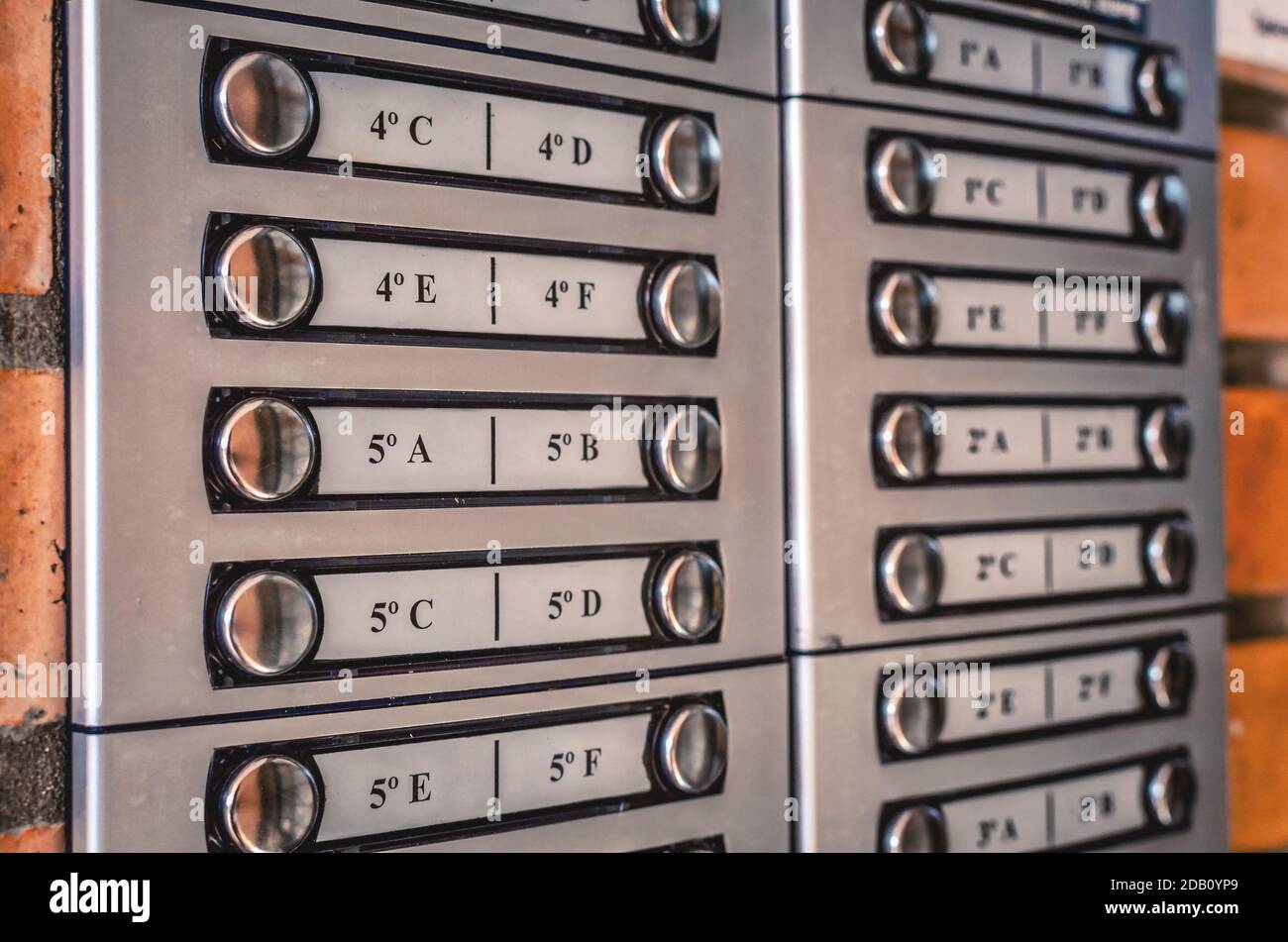 Primo piano sui pulsanti di un citofono all'ingresso di un edificio di appartamenti. Messa a fuoco selettiva sull'avallo. Foto Stock