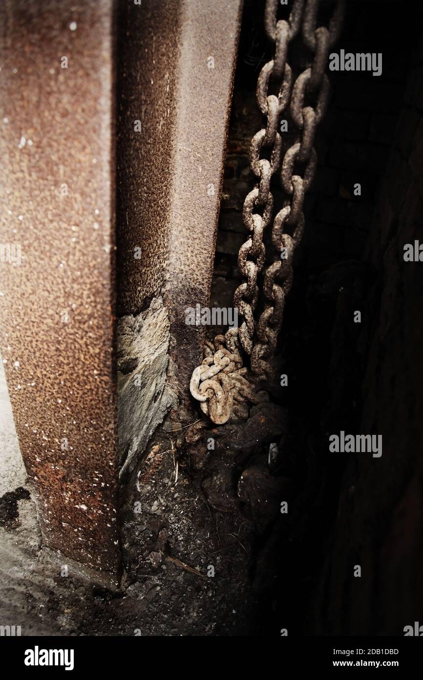 Catene in acciaio arrugginite in edifici industriali abbandonati. Foto Stock
