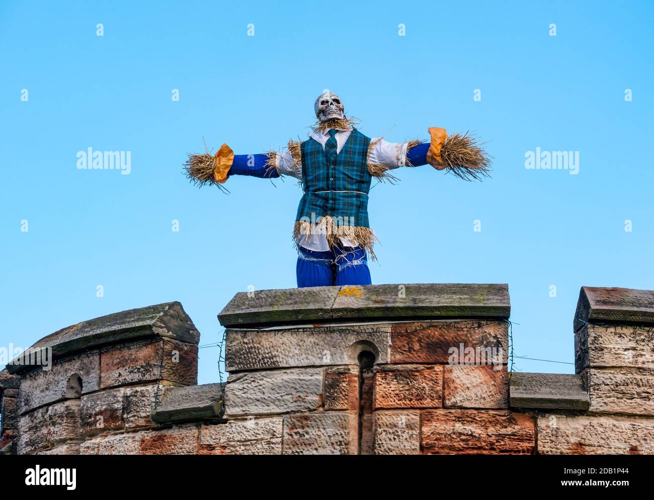 Dirleton, East Lothian, Scotland, UK, gara di truffa al villaggio di Dirleton: Il primo progetto del progetto "motivi per essere allegri" dei buoni vicini del villaggio incoraggia i residenti di tutte le età a creare uno spaventapassare. Il progetto è finanziato da una sovvenzione della North Berwick Coastal Area Partnership. L'obiettivo è portare un po 'di divertimento in questo momento impegnativo. Ambiente storico il castello di Dirleton della Scozia ha anche uno spaventapasseri del cranio in alto nella torre rotonda Foto Stock
