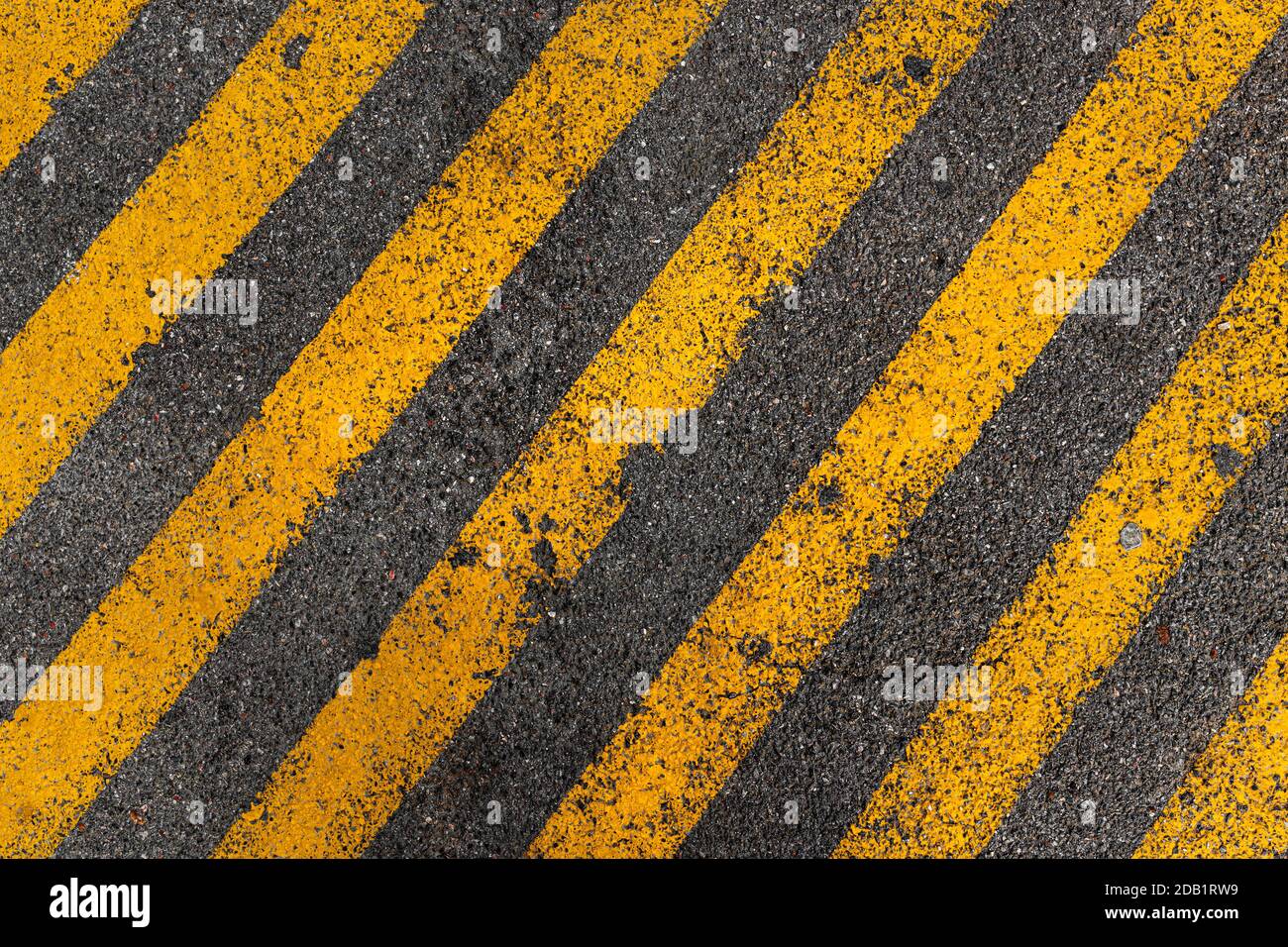 Schema a strisce gialle su asfalto spazio parcheggio come sfondo urbano, vista dall'alto Foto Stock