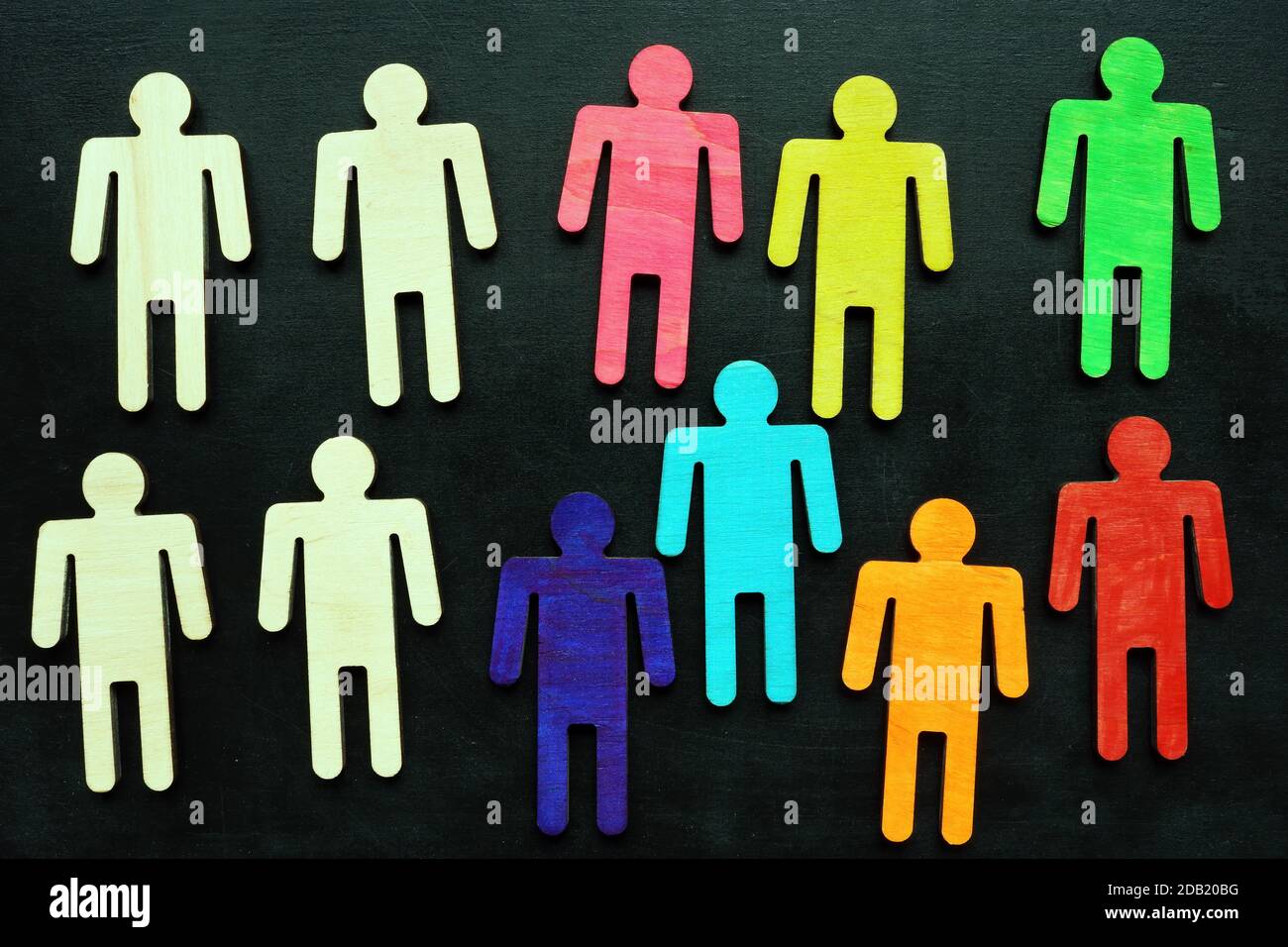 Concetto di uguaglianza e diversità. Figurine multicolore su una lavagna. Foto Stock