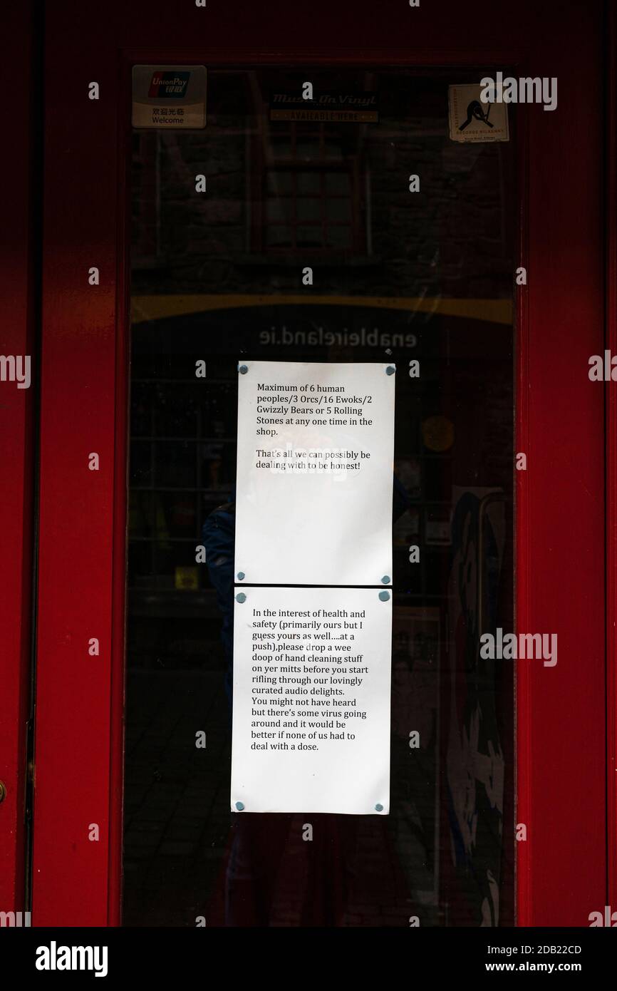 Avviso umoristico alla porta del negozio relativo al numero di clienti consentiti a causa delle restrizioni di Covid 19, Rollercoaster Records, Kilkenny, County Kilkenny, IR Foto Stock