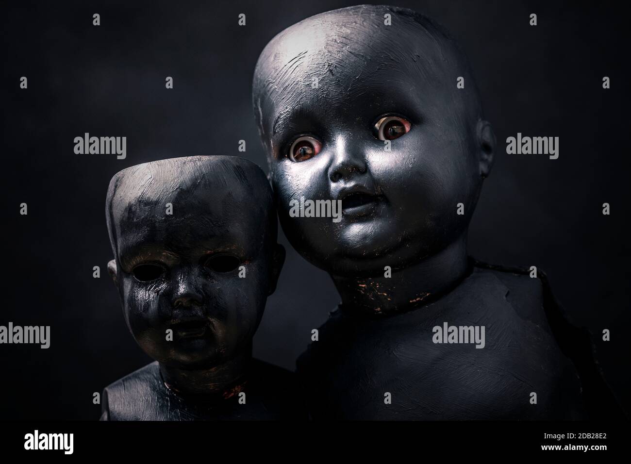 Coppia di creepy dolls nel buio Foto Stock