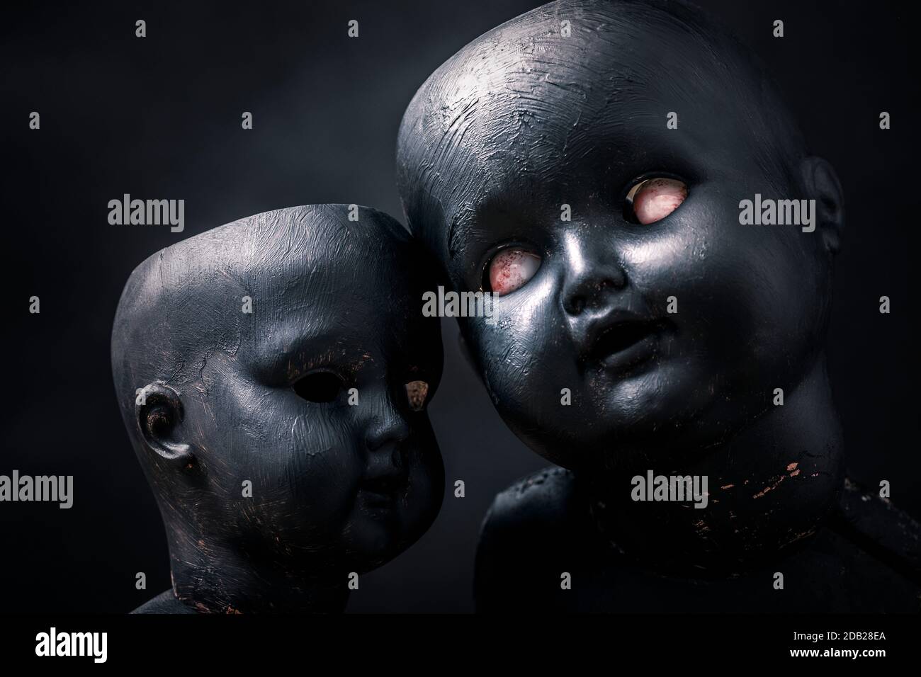 Coppia di creepy dolls nel buio Foto Stock