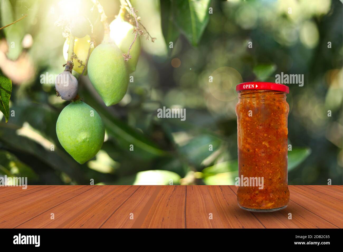 Un vaso di sottaceti piccanti di mango su un tavolo di legno superficie sullo sfondo naturale Foto Stock