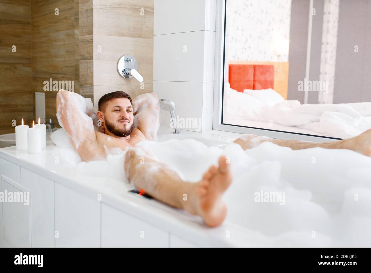 Uomo sdraiato in bagno con schiuma al mattino. I maschi si rilassano nelle  procedure di trattamento della pelle e del corpo Foto stock - Alamy