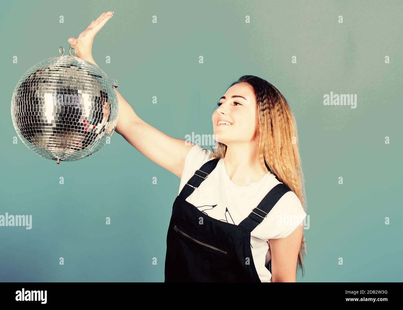 Concorso di ballo. Scuola di ballo. Donna allegra insegnante di danza tenere palla da discoteca. Come circa partito. Night club. Musica retrò. Invito a una festa. Compleanno ragazza. Specchi che riflettono luci atmosfera da discoteca. Foto Stock