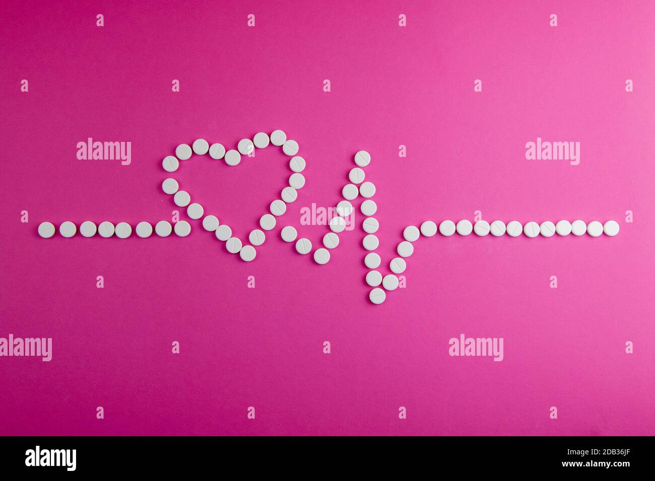 Medicina, sanità e farmacia concetto - pillole e di farmaci in forma di cuore e ritmi del cuore. Foto Stock