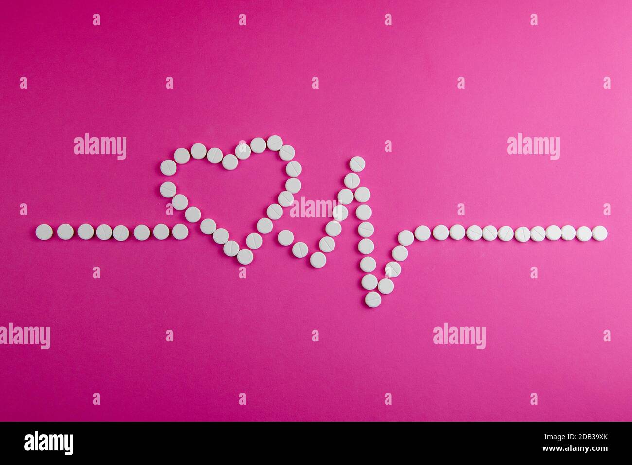 Medicina, sanità e farmacia concetto - pillole e di farmaci in forma di cuore e ritmi del cuore. Foto Stock