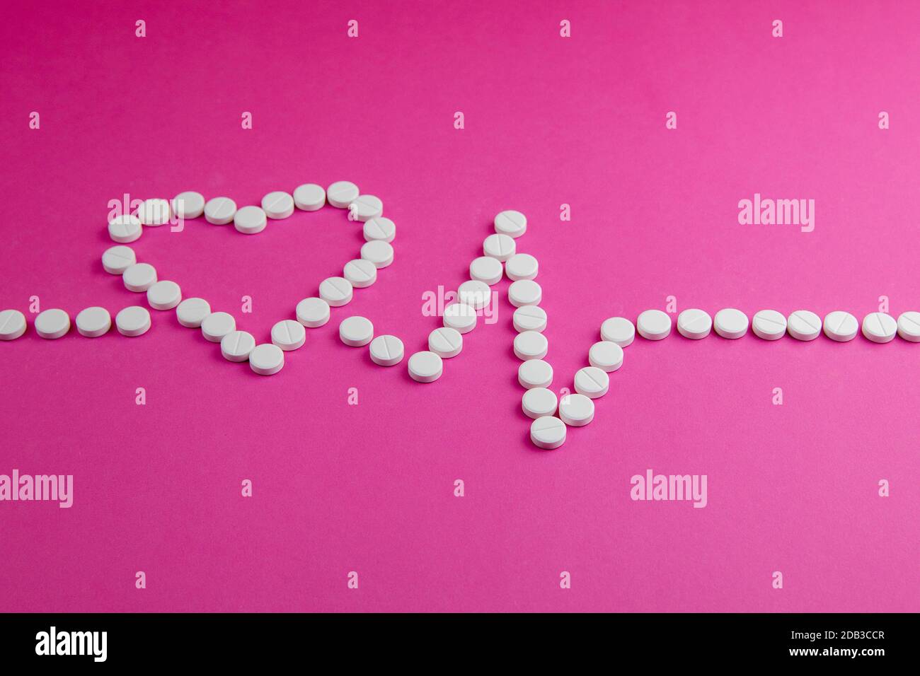 Medicina, sanità e farmacia concetto - pillole e di farmaci in forma di cuore e ritmi del cuore. Foto Stock