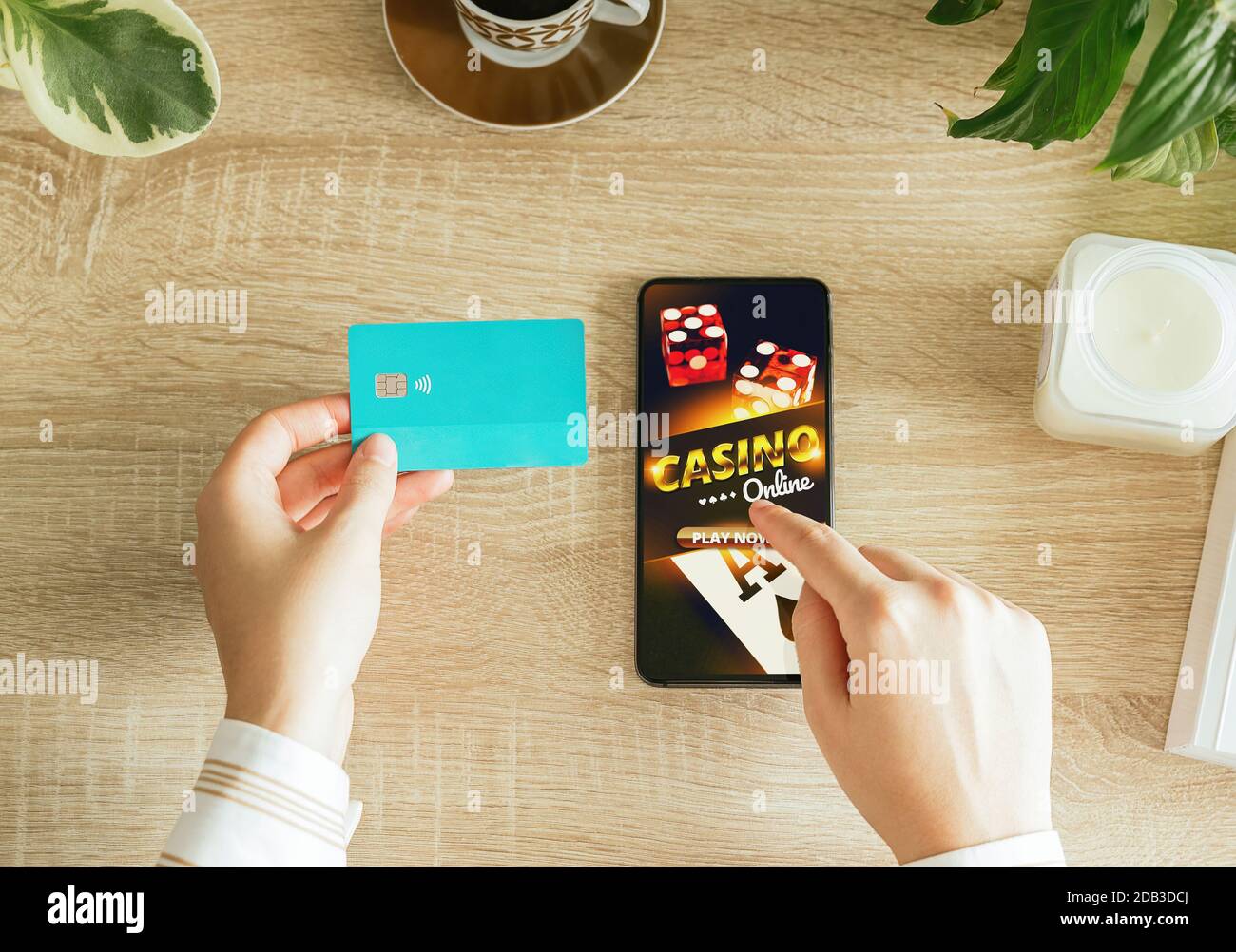 Foto di stock di una donna che va a giocare casinò online dal suo soggiorno e tenendo una carta di credito a pagare. Vista dall'alto Foto Stock