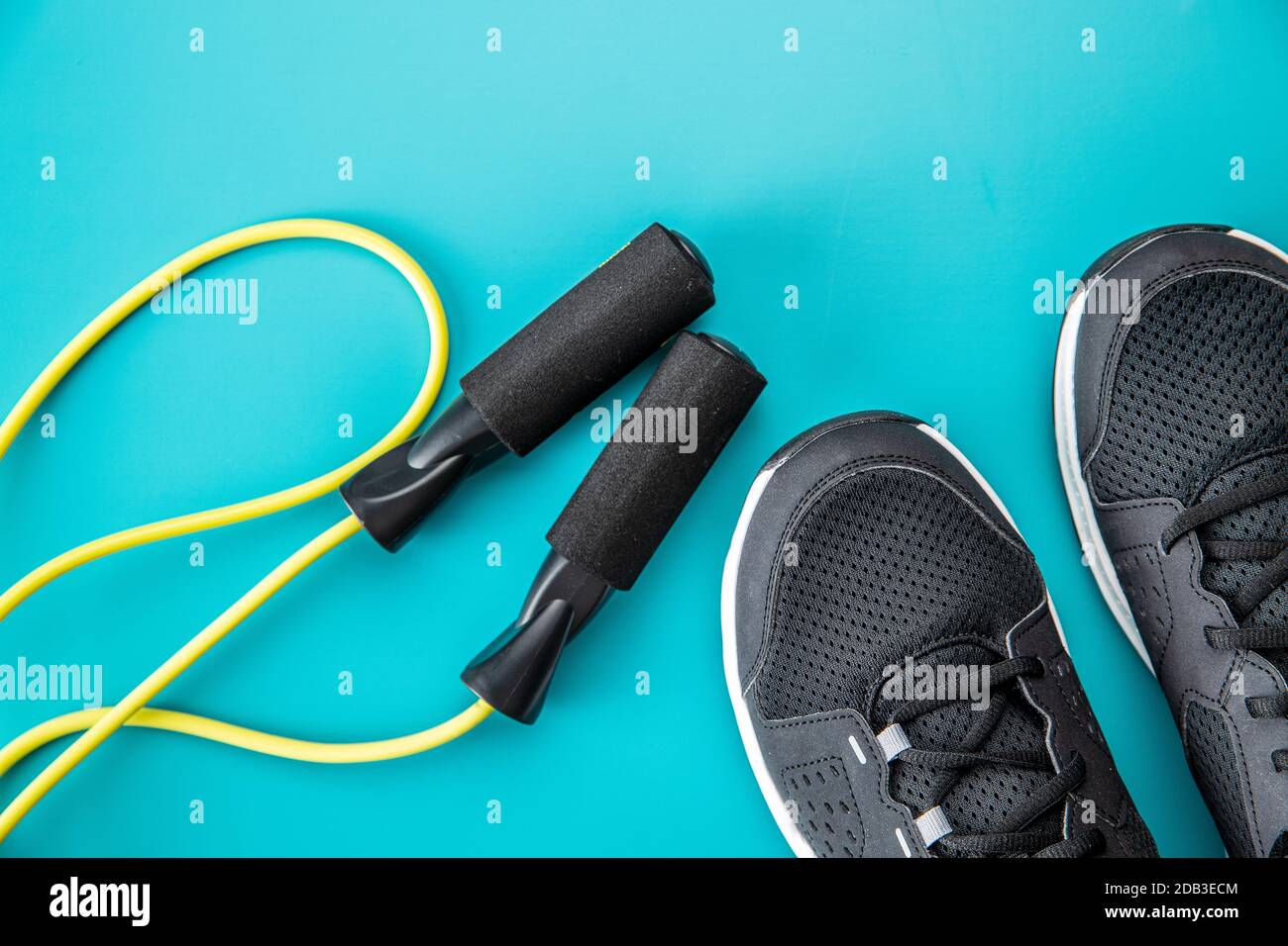 Scarpe sportive nere e corda di salto su sfondo colorato. Vista dall'alto  Foto stock - Alamy