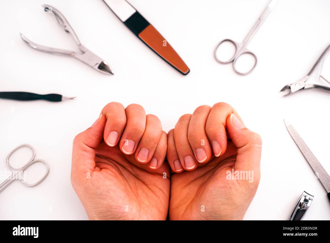 Le mani della donna con manicure non rivestito e gli attrezzi domestici di manicure. Foto Stock