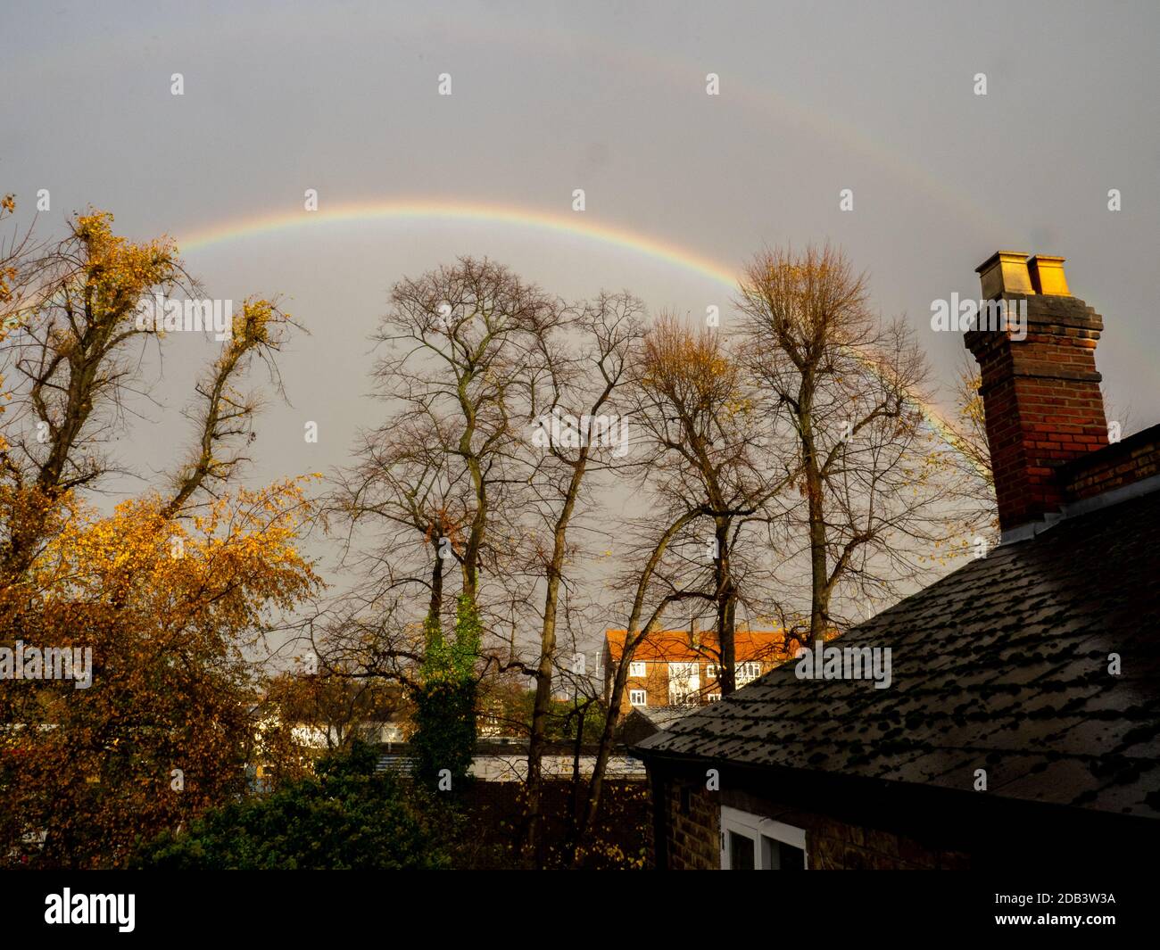 Un arco arcobaleno sopra una strada residenziale a nord di Londra. Foto Stock