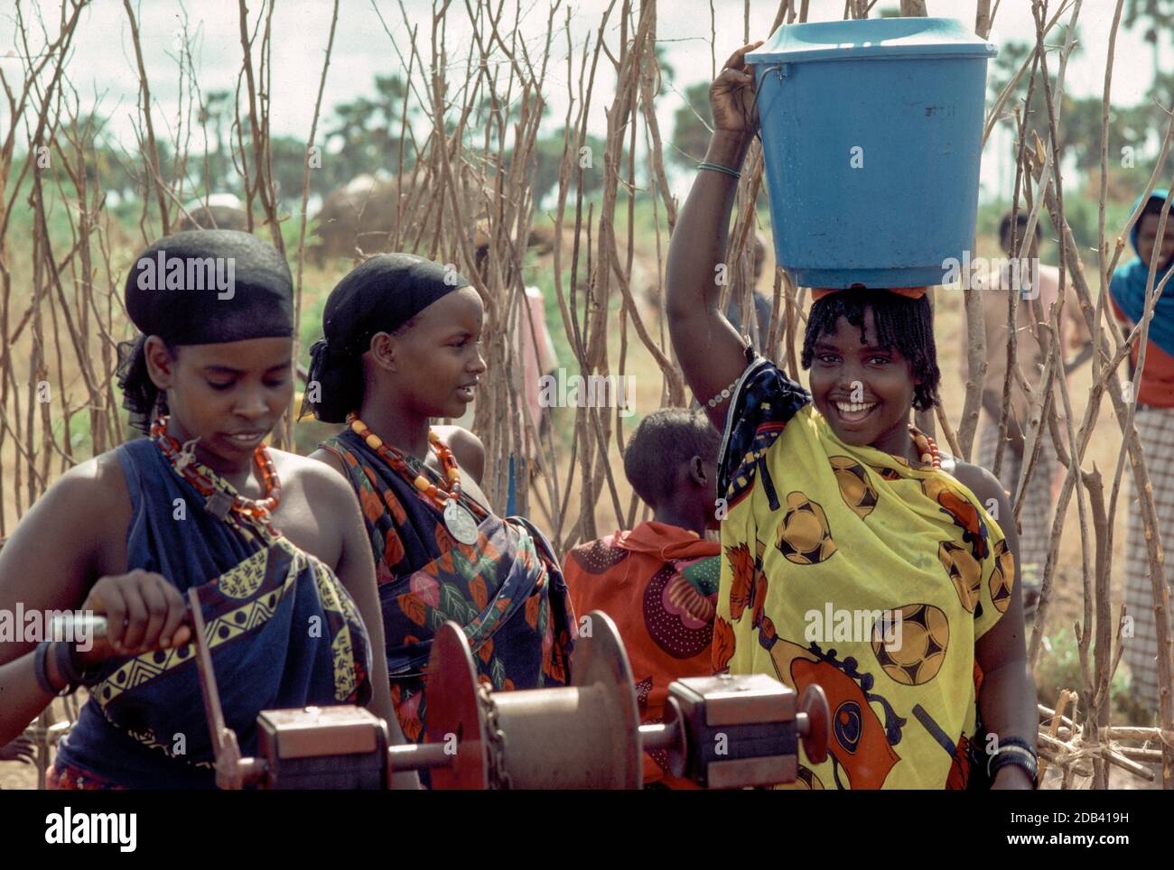 Giovani donne della tribù Wardey che raccolgono acqua dal pozzo della comunità, Wajir, N.E. Kenya Foto Stock