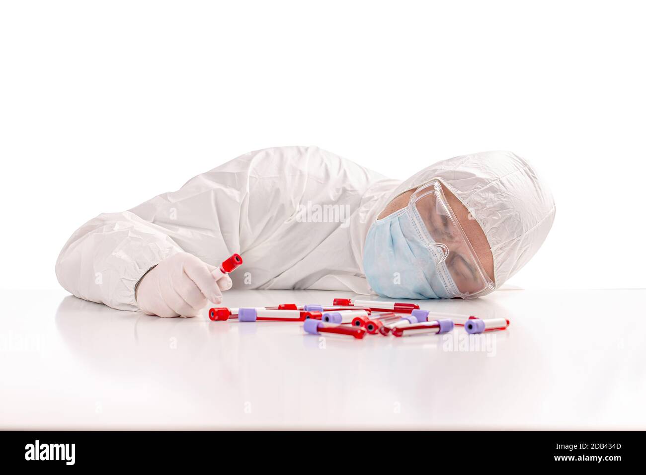Scienziato esausto che dorme in laboratorio, prelevare una provetta per l'analisi del sangue sulla scrivania Foto Stock