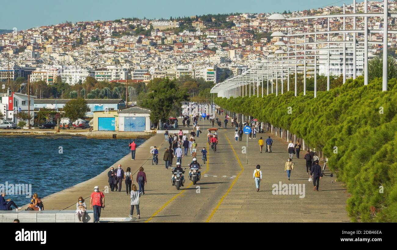 Salonicco, Grecia - Ottobre 26 2020: Polizia greca pattugliando se le persone indossano mascherine covid-19 all'aperto. Persone non identificate con protezione del viso a piedi sulla zona pedonale del lungomare della città. Foto Stock