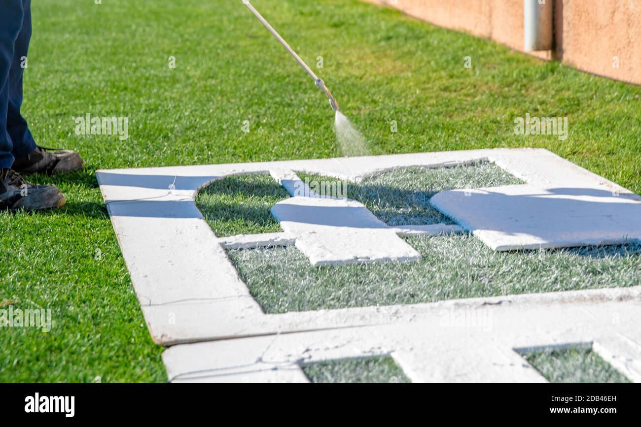 Disegnare lettere sull'erba in bianco su un modello. Il nome del campo di calcio sull'erba. Foto Stock