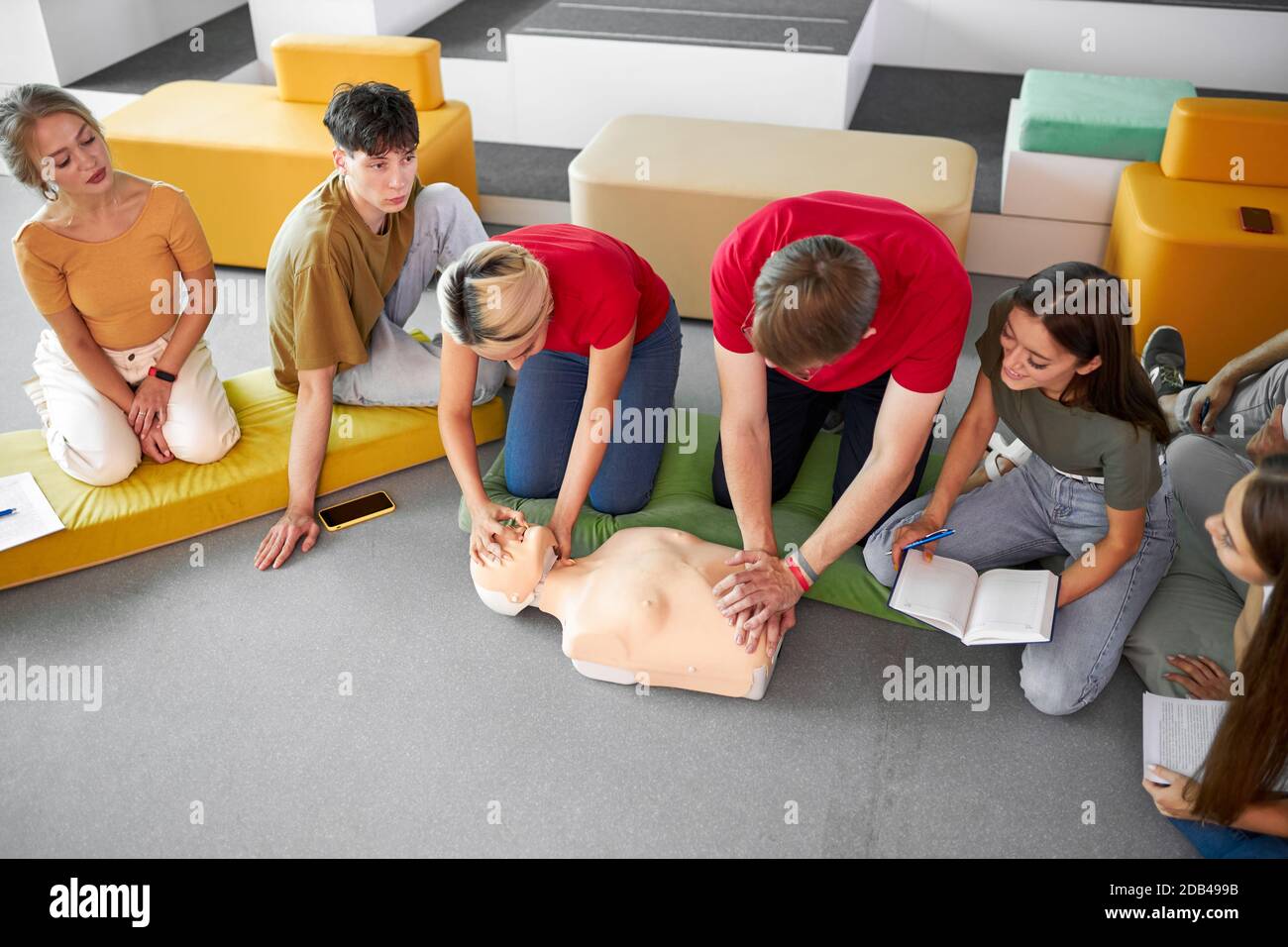 Gruppo di giovani diversi pratica di addestramento di primo soccorso a mano, corso di primo soccorso in CPR manichino. Concetto di abilità di formazione per salvare vite umane, medicina Foto Stock