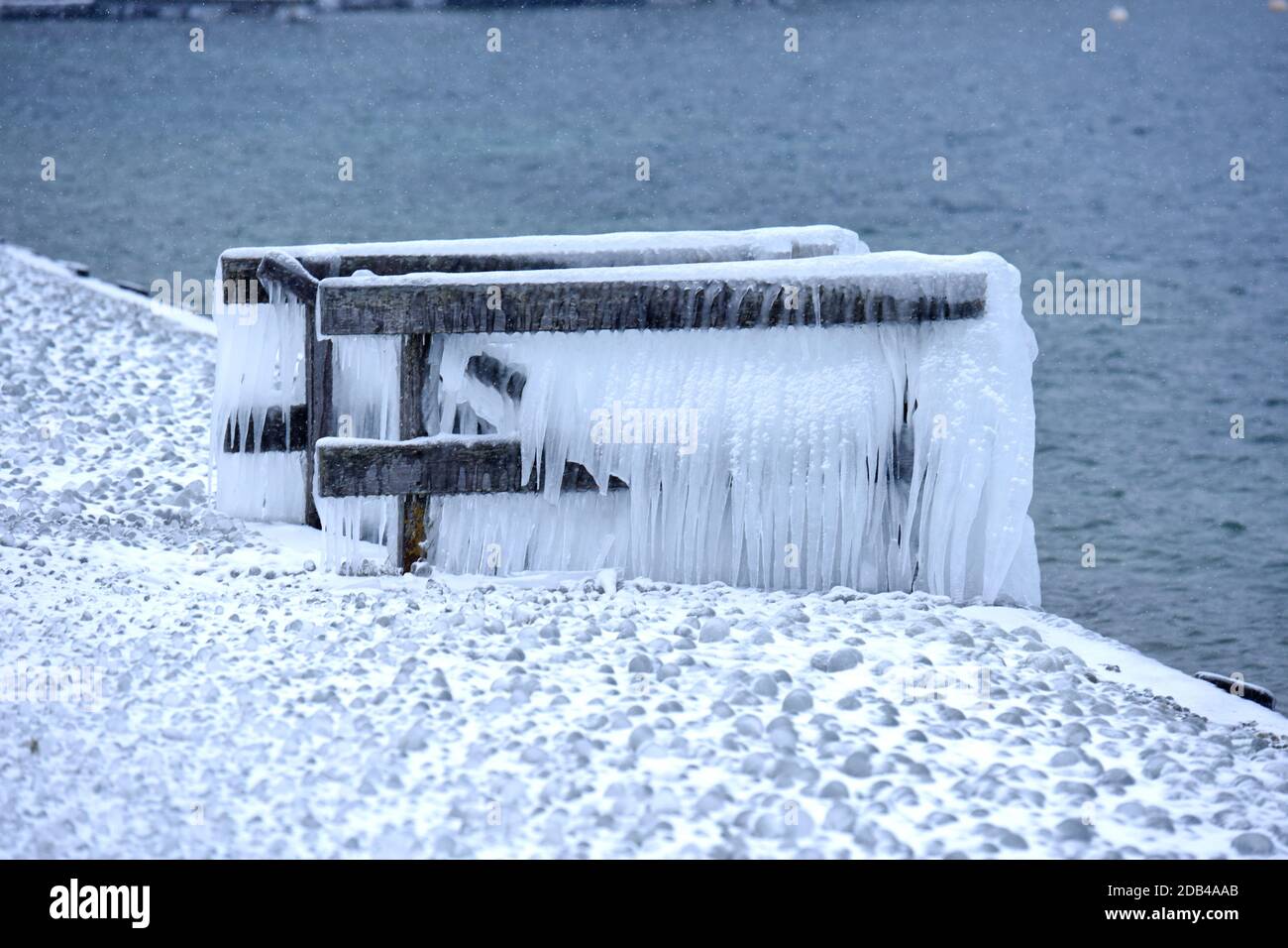 Das Vom Wind ans Ufer gepeitschte Wasser ließ Bänke, Einstiege und Geländer am Ufer des Attersees vereisen. - l'acqua schiacciata dal vento ha fatto le banche, Foto Stock