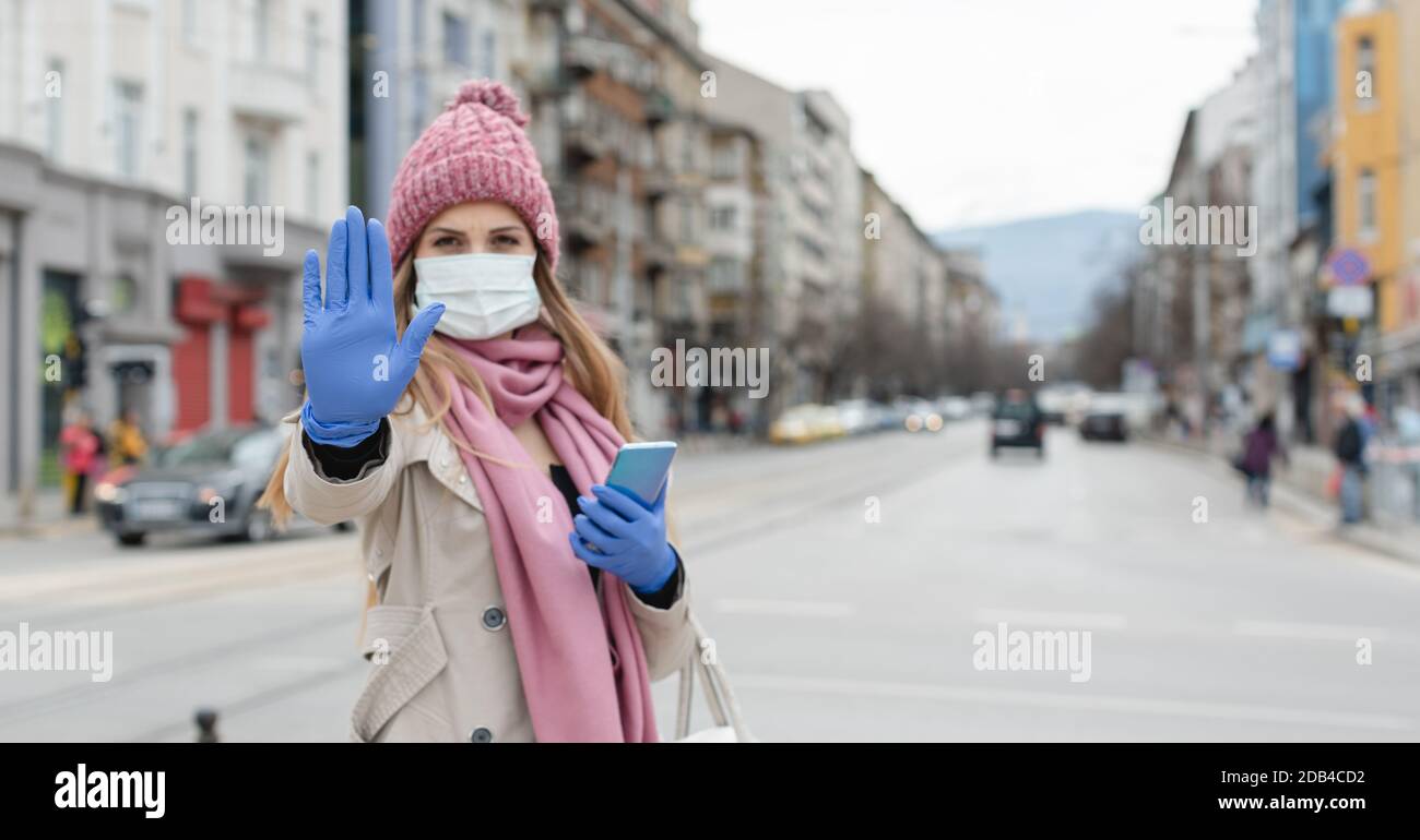 Donna in città vuota di blocco che dà segno di stop alla pandemia del virus corona Foto Stock