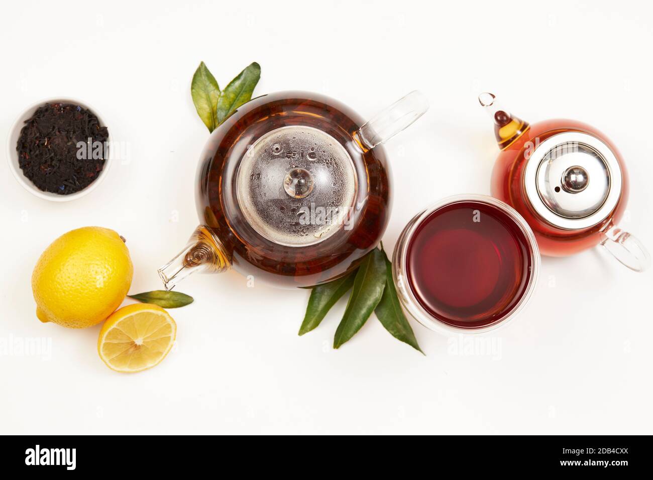 Concetto di tè, teapot e tazza di tè con foglie verdi, limone, vista dall'alto Foto Stock