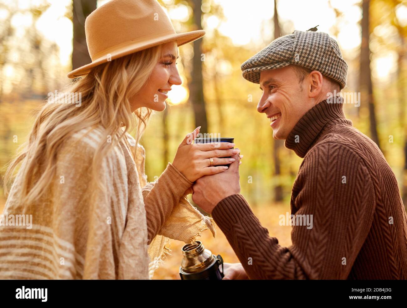 coppia gustando il tè all'aperto nel parco, uomo e donna sposati caucasici hanno tempo romantico. vista laterale Foto Stock