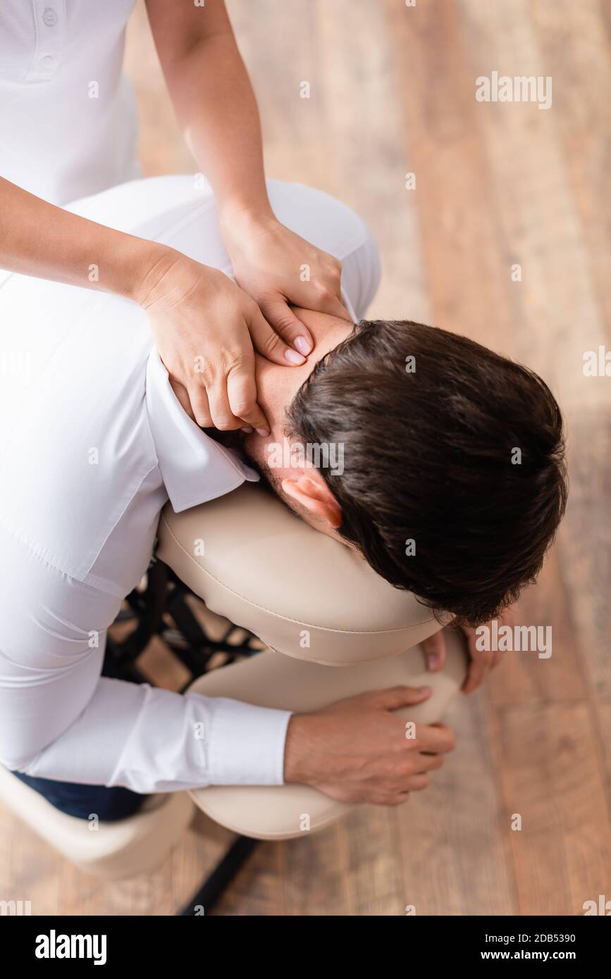 Vista dall'alto della massaggiatrice che fa massaggio seduto del collo del  cliente Foto stock - Alamy