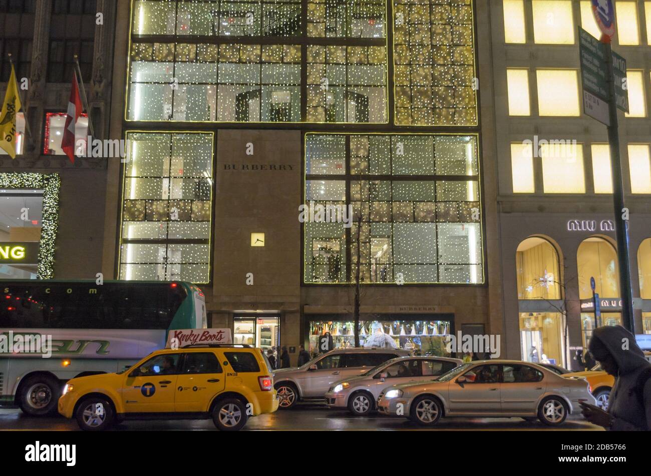 Trafficata Manhattan Avenue e Burberry Store vestiti con decorazioni natalizie con luci luminose sulla facciata. New York City, Stati Uniti Foto Stock