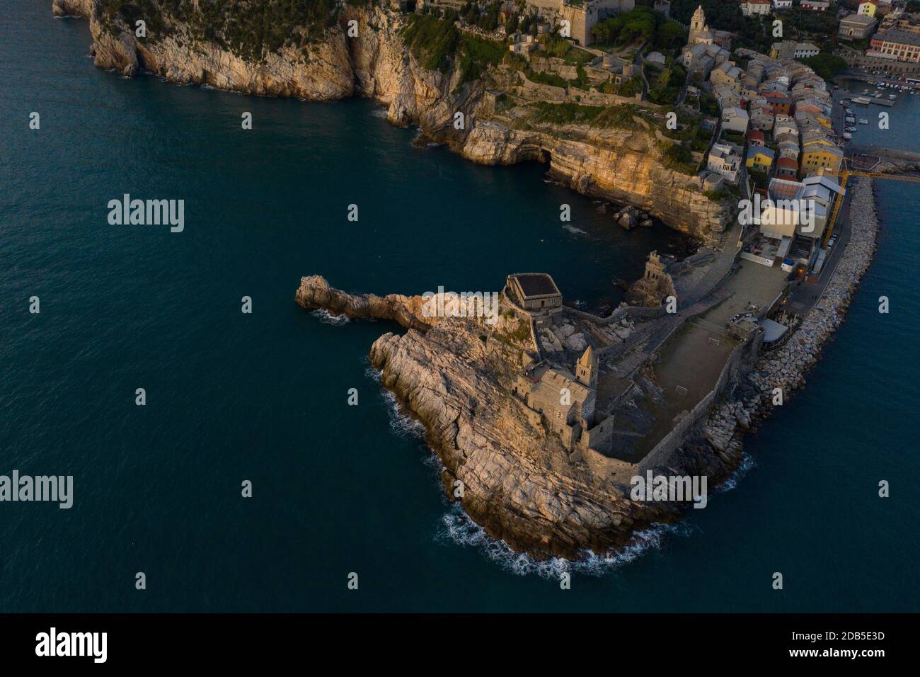 Foto aerea scattata con un drone che sorvola la chiesa di San Pietro in Portovenere visto dal mare con le onde che si infrangono sulla scogliera durante Foto Stock