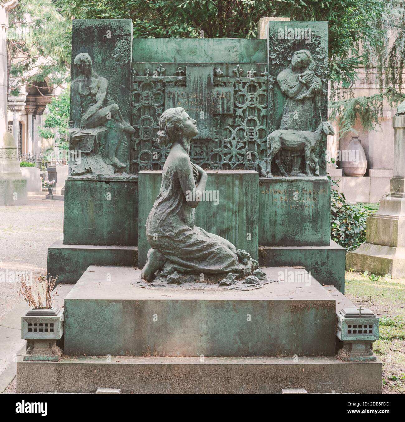 Scultura in bronzo con ragazza inginocchiata che prega sulla tomba del defunto, Cimitero Monumentale, Milano, Italia Foto Stock