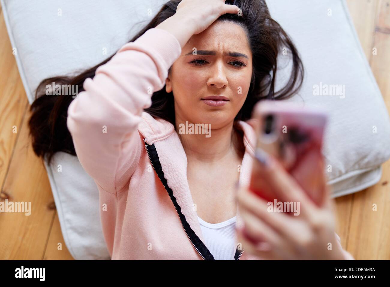 donna che guarda scioccata guardando il messaggio Foto Stock