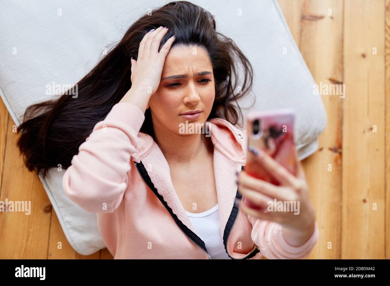 donna che guarda scioccata guardando il messaggio Foto Stock