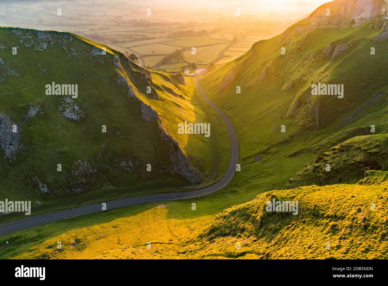 Lunga strada rurale che conduce attraverso la campagna britannica in una bella mattina di primavera con luce sognante. Foto Stock