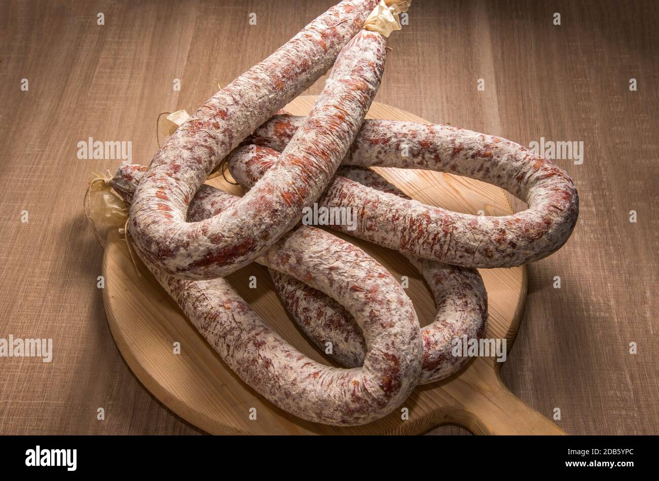Salame piccante italiano su tagliere di legno Foto Stock