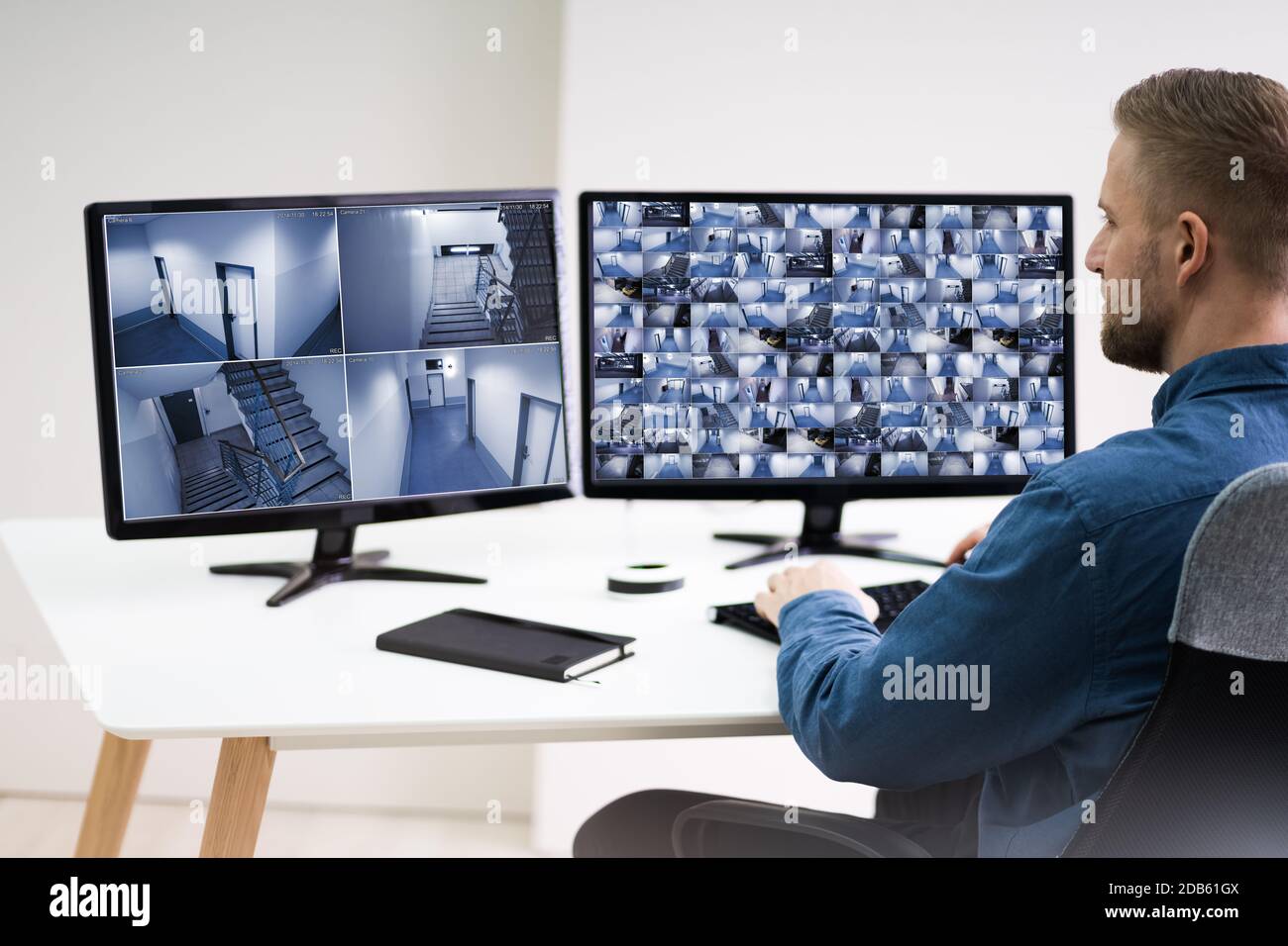 Uomo nella sala di controllo monitoraggio riprese CCTV Foto Stock