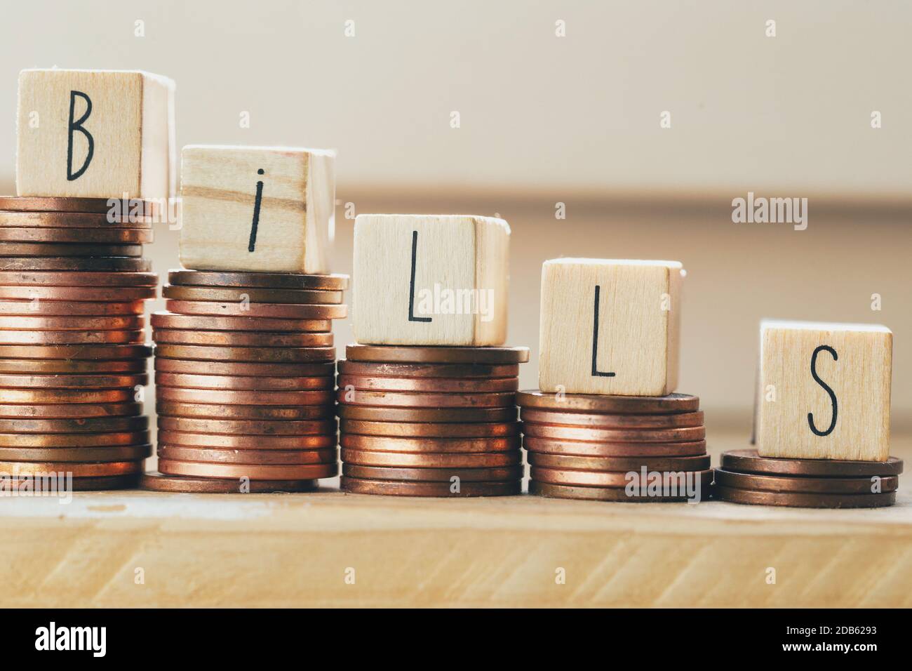 Blocchi di legno con la parola bollette e mucchio di monete, soldi scalini pagamento delle tasse e del debito allo Stato. Concetto di crisi finanziaria e. Foto Stock