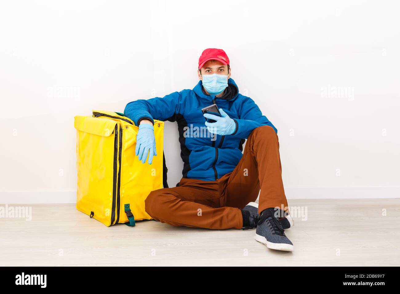 consegna uomo inviare sacchetto di cibo alla manopola della porta per contatto senza contatto o dal pilota di consegna in casa anteriore per la distanza sociale per rischio di infezione. Foto Stock