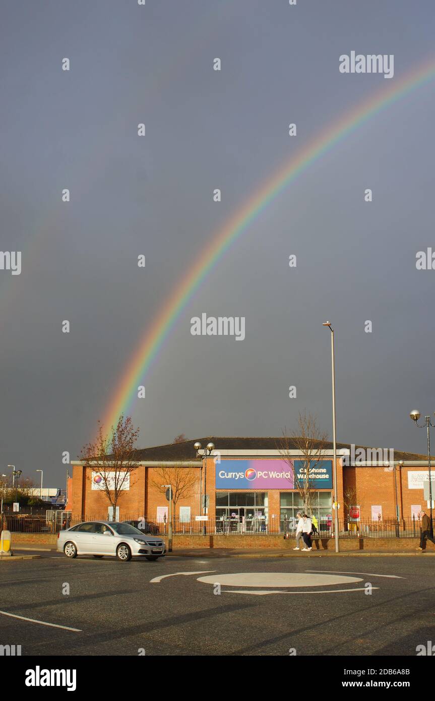 Superstore PC World illuminato dal sole su West St. Con cielo scuro e arcobaleno Foto Stock