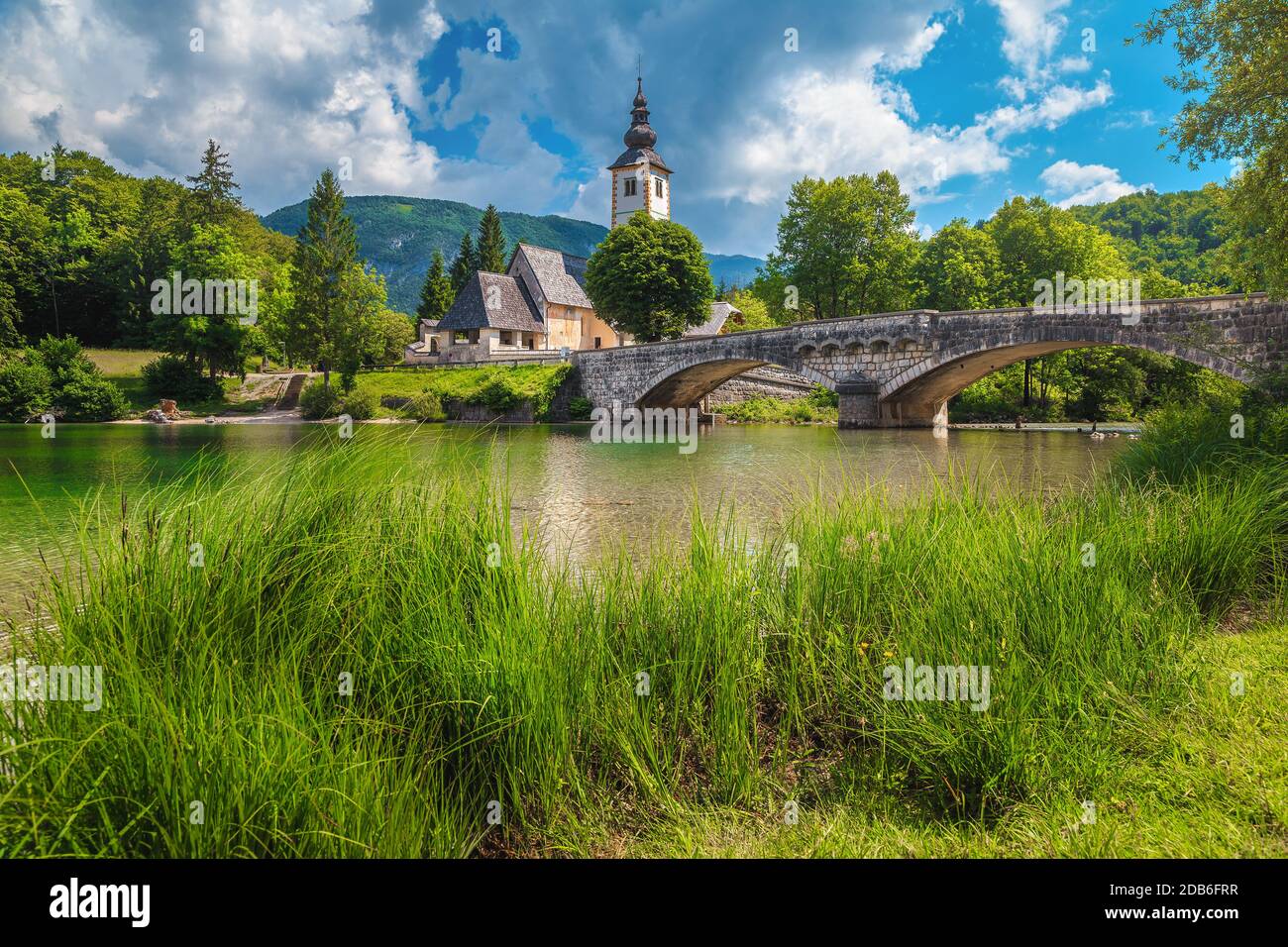 Splendido paesaggio estivo e luogo di viaggio con famosa chiesa alpina sulla riva del lago di Bohinj, Slovenia, Europa Foto Stock