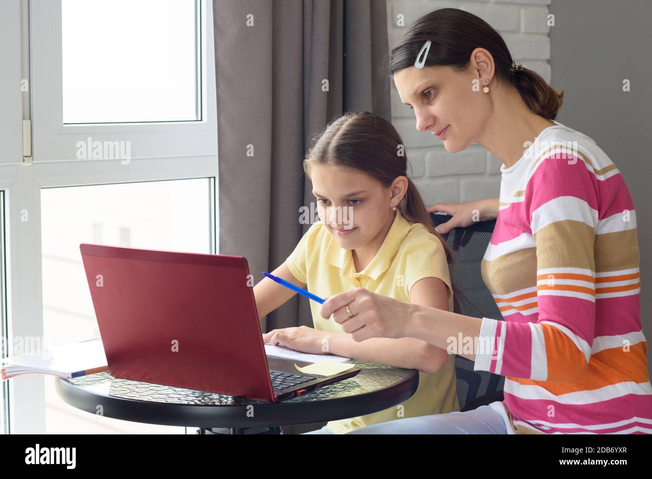 Un tutor aiuta una ragazza ad imparare online attraverso Internet Foto Stock
