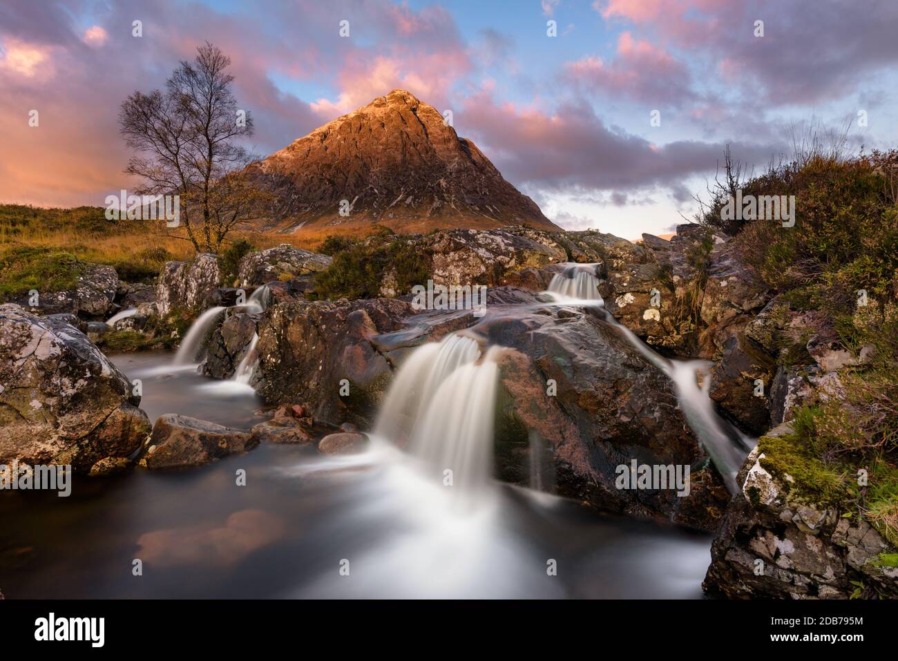 Bellissima cascata a Buachaille Etive Mor nelle Highlands scozzesi all'alba. Foto Stock